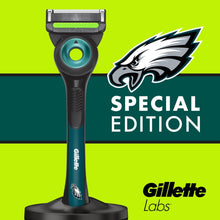 Men's razor with teal accent and black handle on magnetic stand