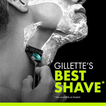 Razor held in hand with teal cartridge, shaving foam visible