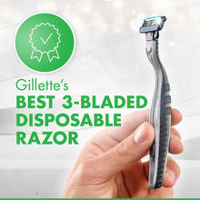 Disposable 3-blade razor held in hand with shaving cartridge facing up
