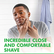 Men's disposable razor held near face during shaving with shaving foam