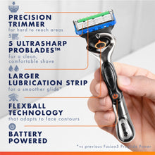 Men's razor with blue trimmer head held in hand, black and silver handle.