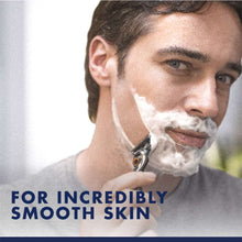 Man shaving with razor while holding shaving foam on face; product benefit text below.