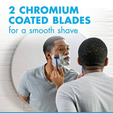 Blue disposable razor being used by a man shaving with lather