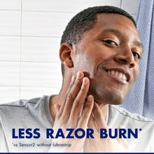 Disposable blue razor in hand with shaving foam on chin and cheek
