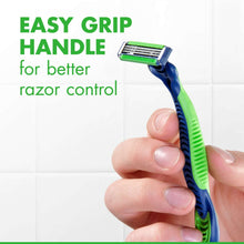 Disposable razor with green-and-blue easy-grip handle in use