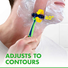 Hand holding disposable razor with white shaving foam, green-and-blue handle