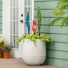Set of 3 glass garden stakes with blue, red, and yellow swirled glass spikes in pot.