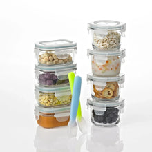 Stacked clear glass baby food containers with colorful contents and translucent lids