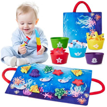 Toddler cloth fishing game set with blue ocean mat, red handles, and numbered stacking cups
