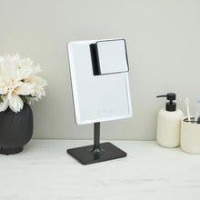Adjustable LED mirror standing on a black base with lighted display panel