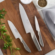 Chef's knife set on wooden cutting board, three knives with perforated handles