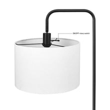 White linen drum shade with black rotary switch on matte black floor lamp