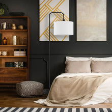 Matte black floor lamp with white linen drum shade and arched stand