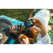 Action camera held in hand while recording a group outdoors