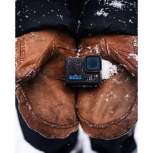Action camera tucked in a jacket pocket with snowy texture