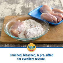 Flour-coated food in glass bowl with hand sprinkling flour