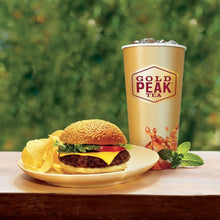 Sweet tea cup with burger and sliced fruit on a plate