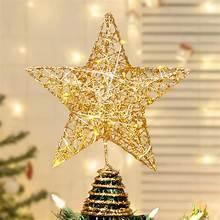 Gold LED Christmas tree topper star above a lit Christmas tree