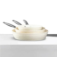 Cream hammered ceramic nonstick skillet set with matching lids, nesting pans