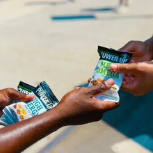 Hands holding a mega omega trail mix snack bag