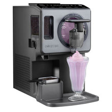 Automatic frozen drink maker dispensing pink smoothie into a clear glass