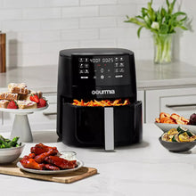 Black Gourmia 6-qt air fryer with open basket, cooking food inside