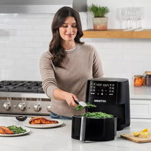 Black Gourmia 6-qt air fryer with open basket beside prepared ingredients