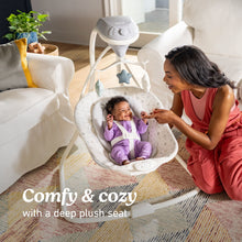 Graco baby swing with plush seat and hanging star mobile, baby seated