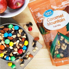 Caramel Mountain trail mix pouch beside bowl of multicolor snack pieces