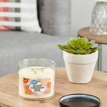 Glazed Cinnamon Buns scented candle in clear glass jar with visible flames