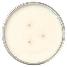 White candle wax top with three small melted points in clear glass jar
