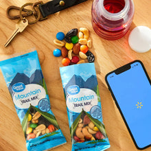 Mountain Trail Mix pouches with mixed candies and nuts on a wood surface.