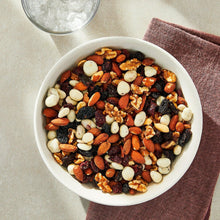 Bowl of probiotic trail mix with mixed nuts, seeds, raisins, and white pieces