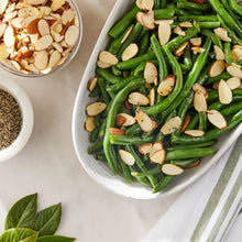 Bowls with sliced almond pieces and chopped green beans sprinkled with almonds.