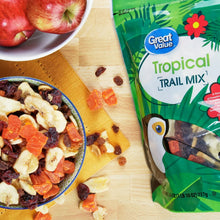 Tropical trail mix pouch beside a bowl of mixed nuts and dried fruit