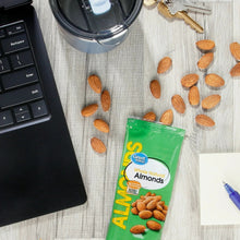 Whole natural almonds pouch with scattered whole almonds around it