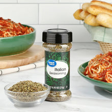 Italian seasoning bottle with black cap beside a small bowl of dried herbs