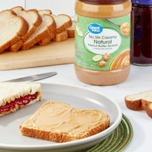 Creamy peanut butter spread jar with toast slices and knife on plate