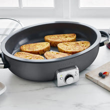 Graphite electric ceramic nonstick oval skillet with sliced bread arranged inside