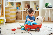 Orange kids wagon toy with a small plush inside on a play mat
