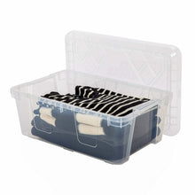 Two clear plastic stackable storage bins with open lids holding folded striped clothes