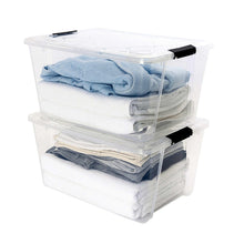 Stacked clear storage bins with latching lids holding folded blue linens
