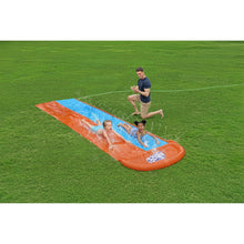 Inflatable double-lane water slide with kids riding on orange and blue lanes