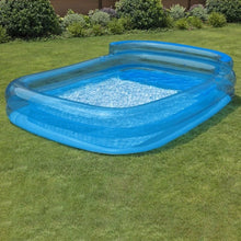 Inflatable pool with raised blue sides on grass, open center with water