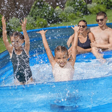 Inflatable blue pool with family playing, water splashing above the rim
