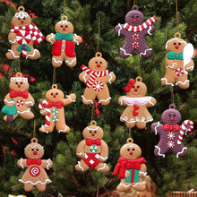 Gingerbread man ornaments hanging on a Christmas tree, red and striped outfits