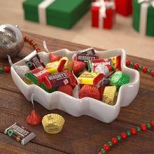 Assorted chocolate candies in a white bowl with mixed foil and paper wrappers