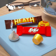 Mini chocolate bars and wrapped candies on a light blue board, incl. Heath and KitKat