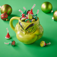 Grinch-themed wrapped milk chocolate candies in a green mug