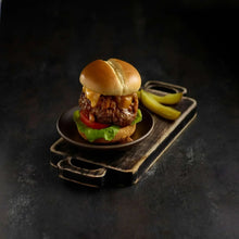 Mini burger with chili, bun, and lettuce on a plate with pickles